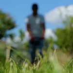 Man Gardaener Mowing The Lawn With Lawn Mower Near House. Green G
